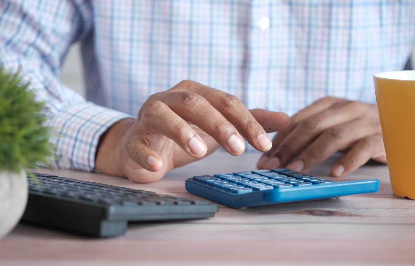 Man typing on a calculator